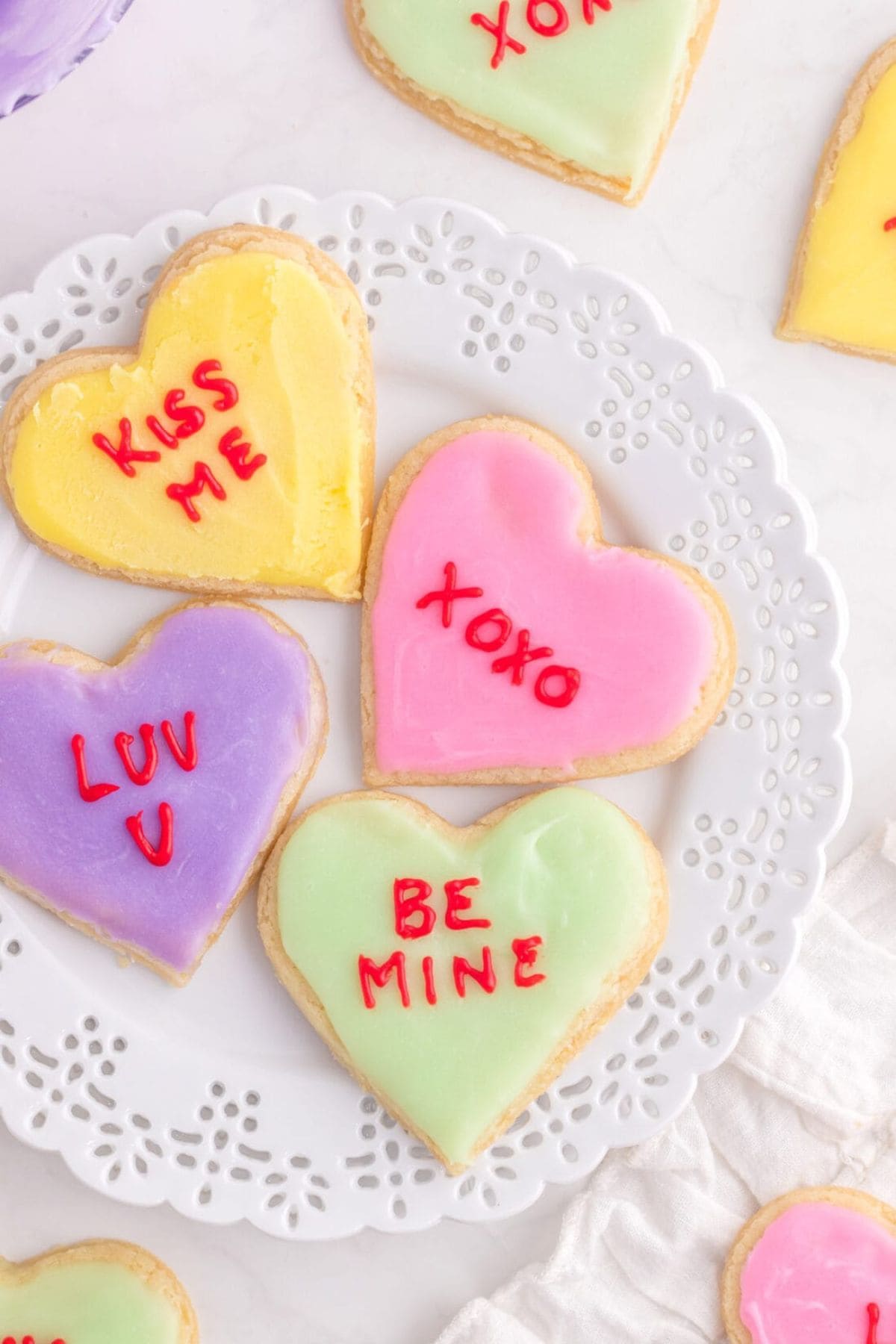 Frosted heart cookies on plate.