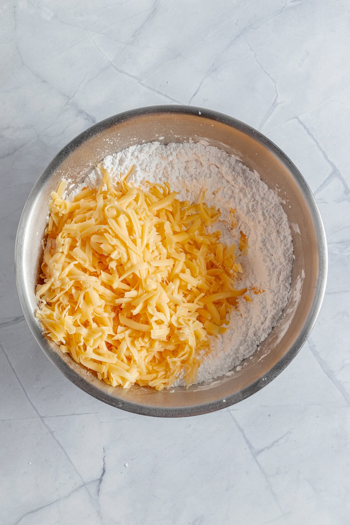 Incorporating the shredded cheese.