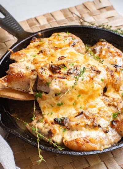 Taking a pork chop out of the pan.