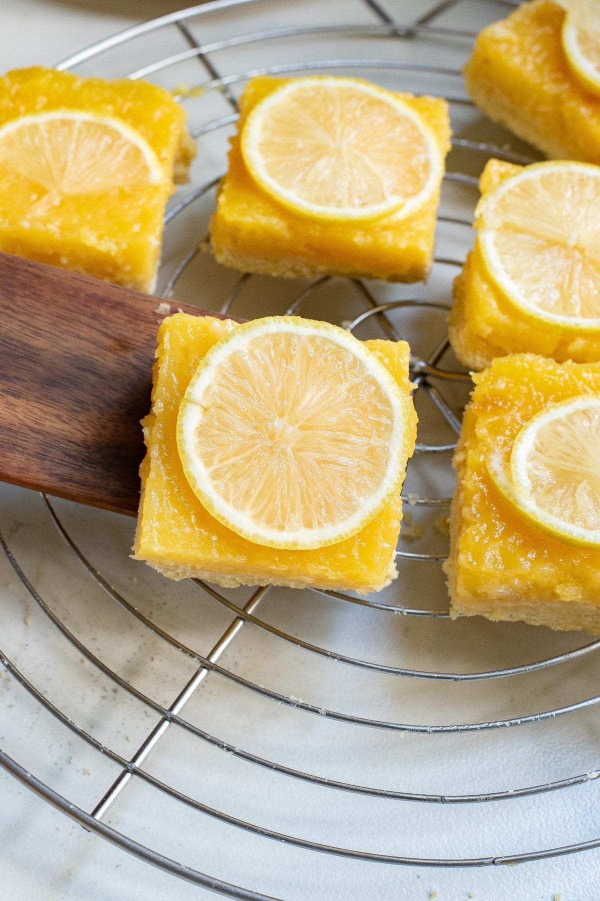 Lemon pie bars on a cooling rack.