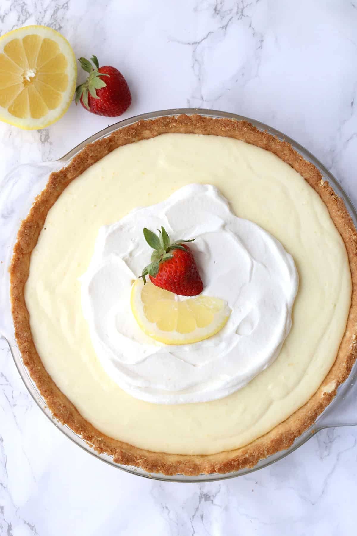 Lemon sour cream pie in glass dish.