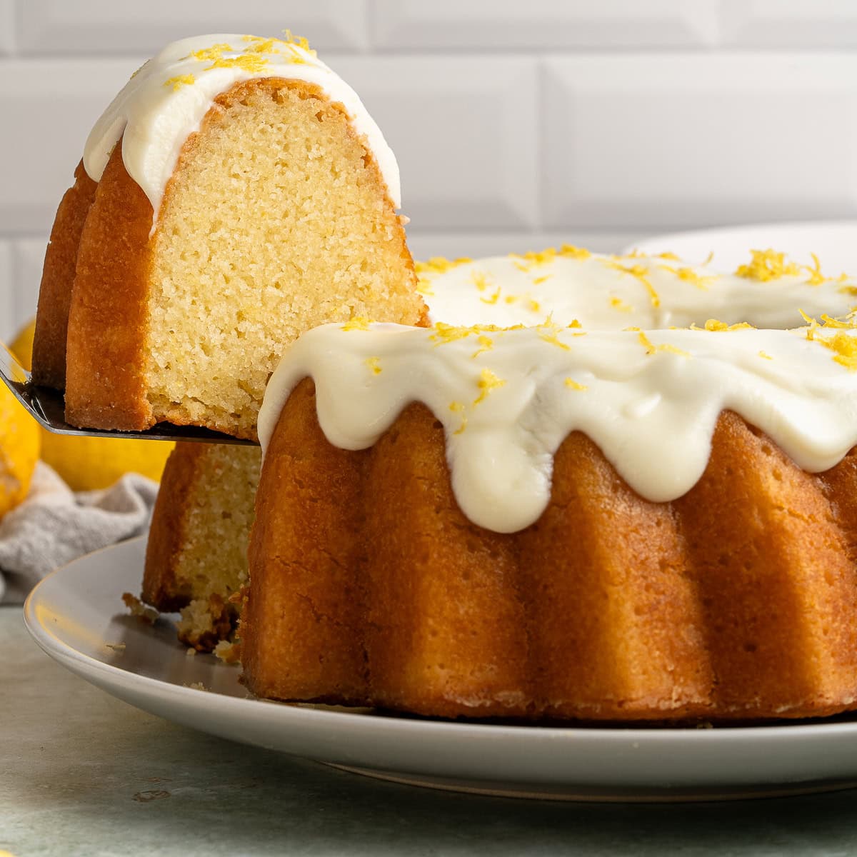 This Limoncello Cake is filled with luscious ingredients like lemon juice, lemon zest and limoncello to give you a lovely citrus flavor to this rich and butter cake. Taking a slice from the bundt.