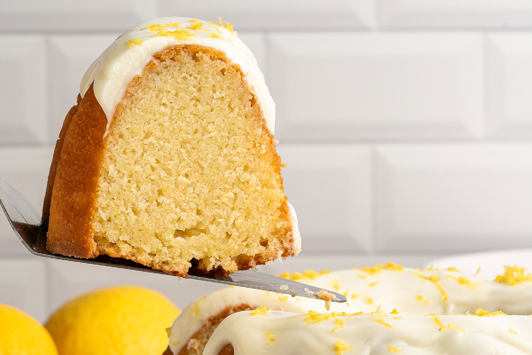 This Limoncello Cake is filled with luscious ingredients like lemon juice, lemon zest and limoncello to give you a lovely citrus flavor to this rich and butter cake. Taking a slice of cake.