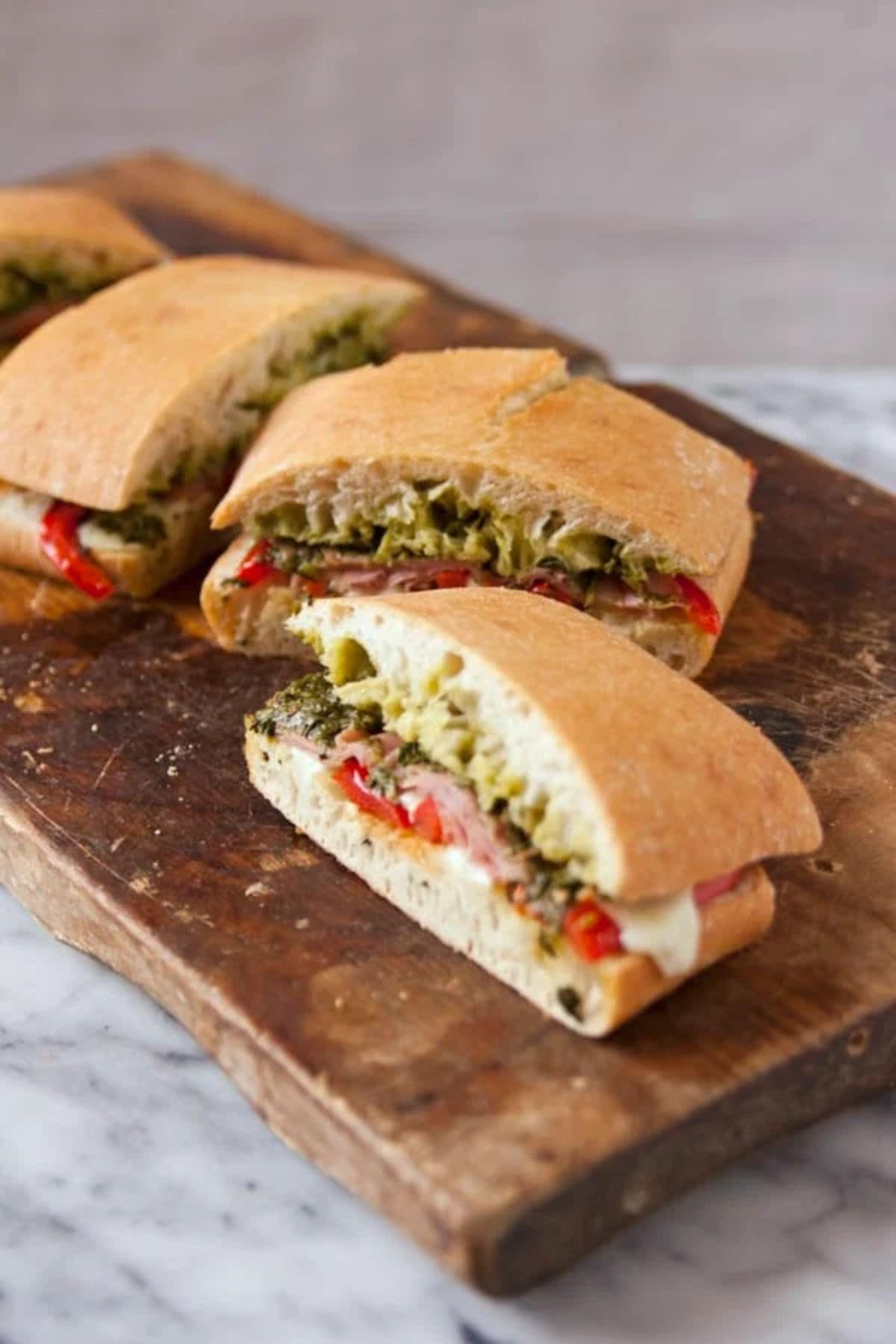 Get outside and enjoy the day with these 50 Picnic Basket Essentials. There is something for everyone to pack the perfect picnic and enjoy family time and the great outdoors. Baked Ham Panini's on a cutting board.