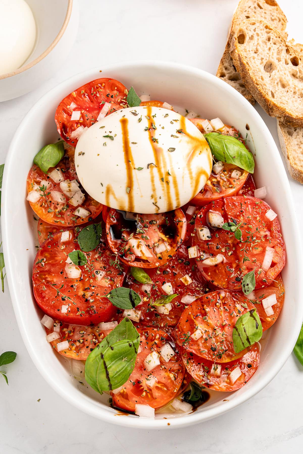 A Tomato Burrata Salad like this can be a show-stopper for any get-together. Use fresh heirloom tomatoes if available. They are the best with the creamy burrata. Served tomato burrata salad.