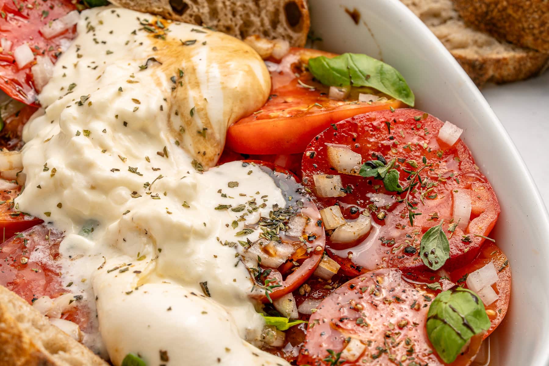 A Tomato Burrata Salad like this can be a show-stopper for any get-together. Use fresh heirloom tomatoes if available. They are the best with the creamy burrata. Burrata spread over tomatoes.