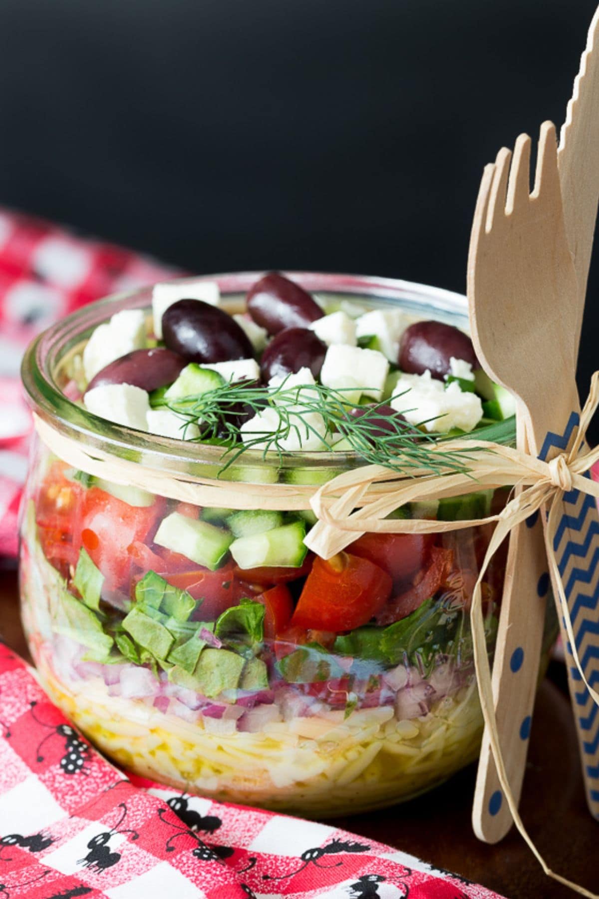 Get outside and enjoy the day with these 50 Picnic Basket Essentials. There is something for everyone to pack the perfect picnic and enjoy family time and the great outdoors. Greek summer salad in a glass mason jar.