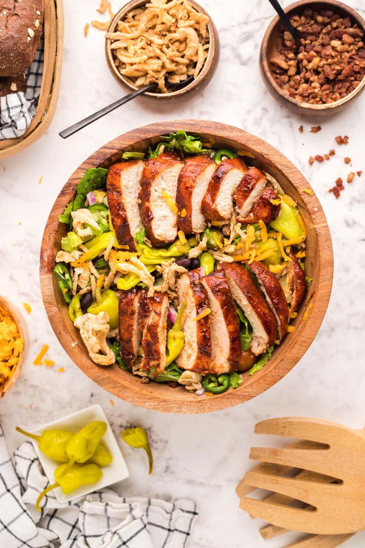 Wooden bowl full of grilled chicken salad.