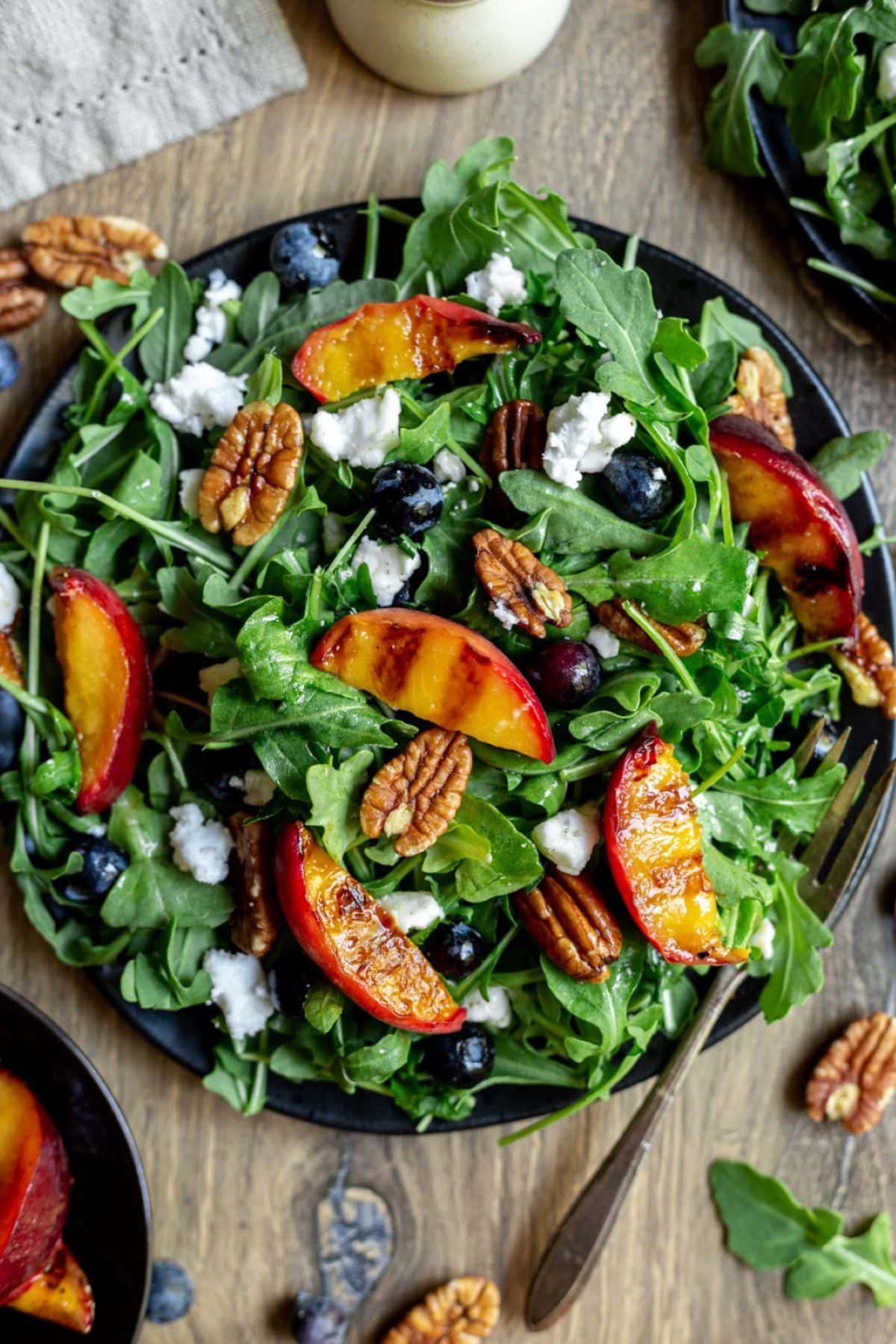 Dark bowl full of grilled peach salad.