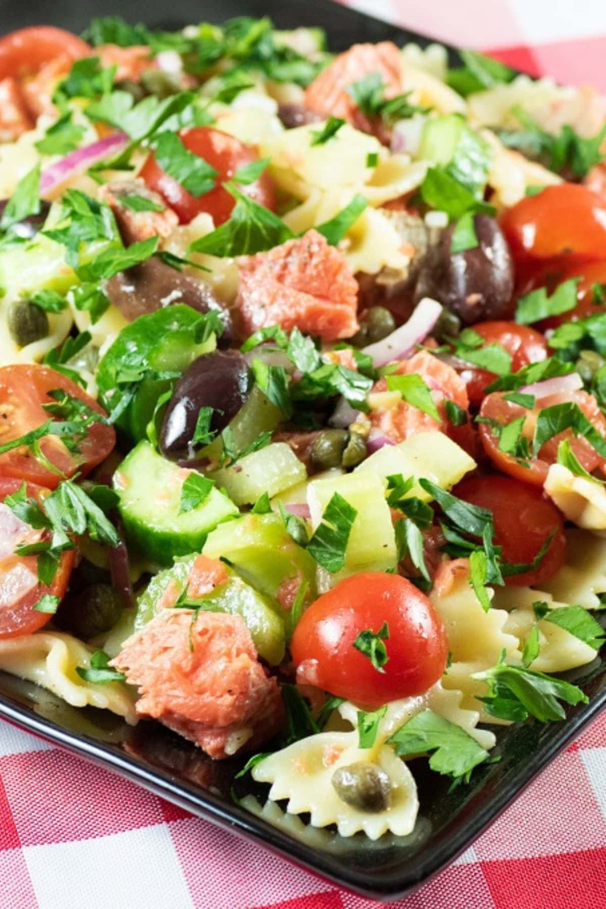 Dark plate full of salmon pasta salad.