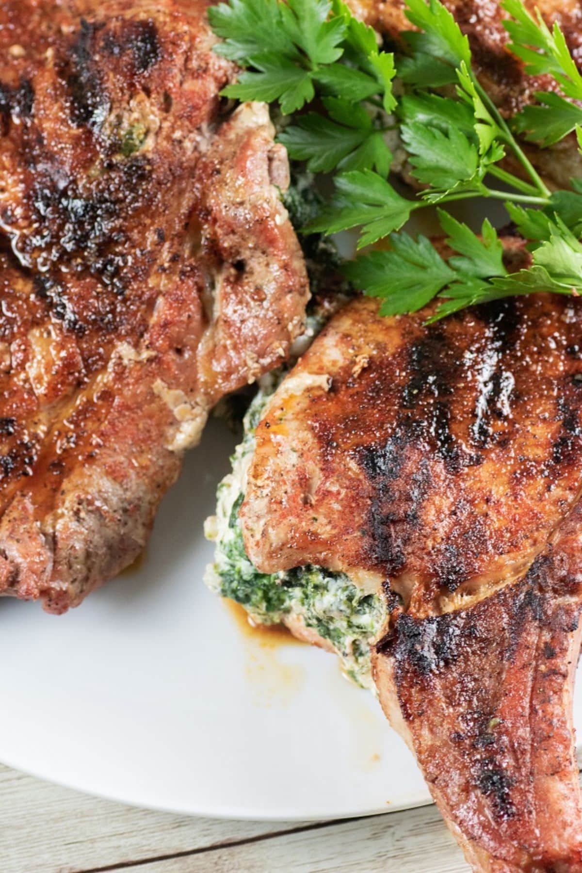 Stuffed pork chops on a white plate.
