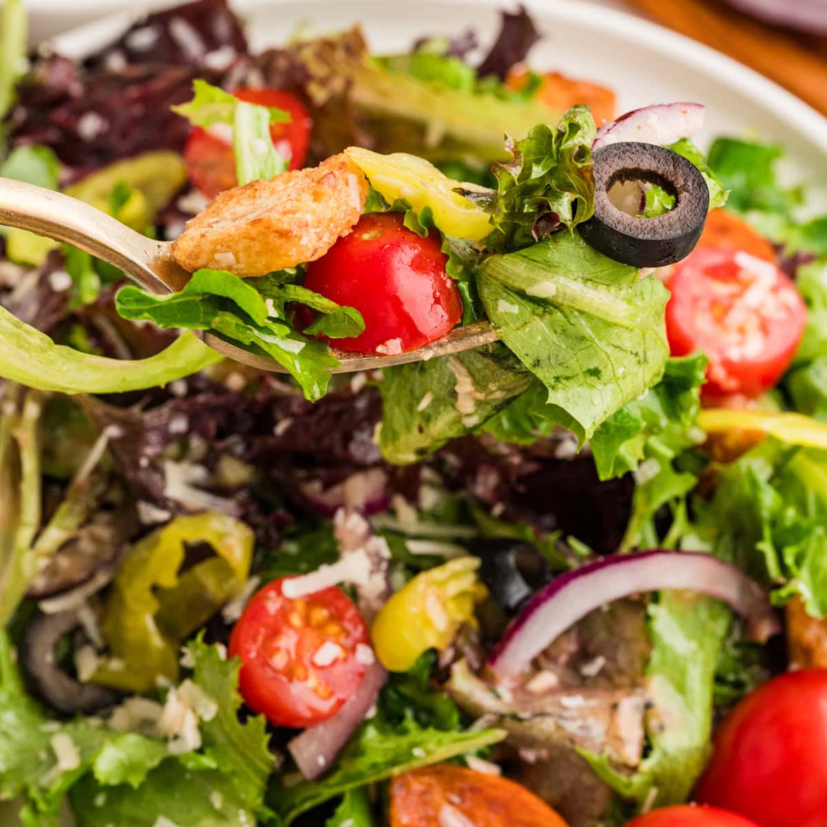 An Italian Chopped Salad adds a lot of bold flavor to any meal, but also it is healthy and delicious. This salad goes with so many mains you will want to make it again and again. Taking a forkful of salad.