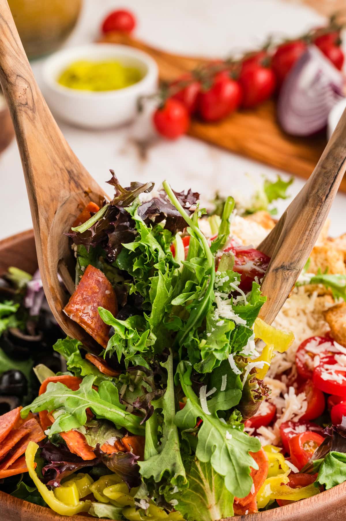 An Italian Chopped Salad adds a lot of bold flavor to any meal, but also it is healthy and delicious. This salad goes with so many mains you will want to make it again and again. Tossing salad.