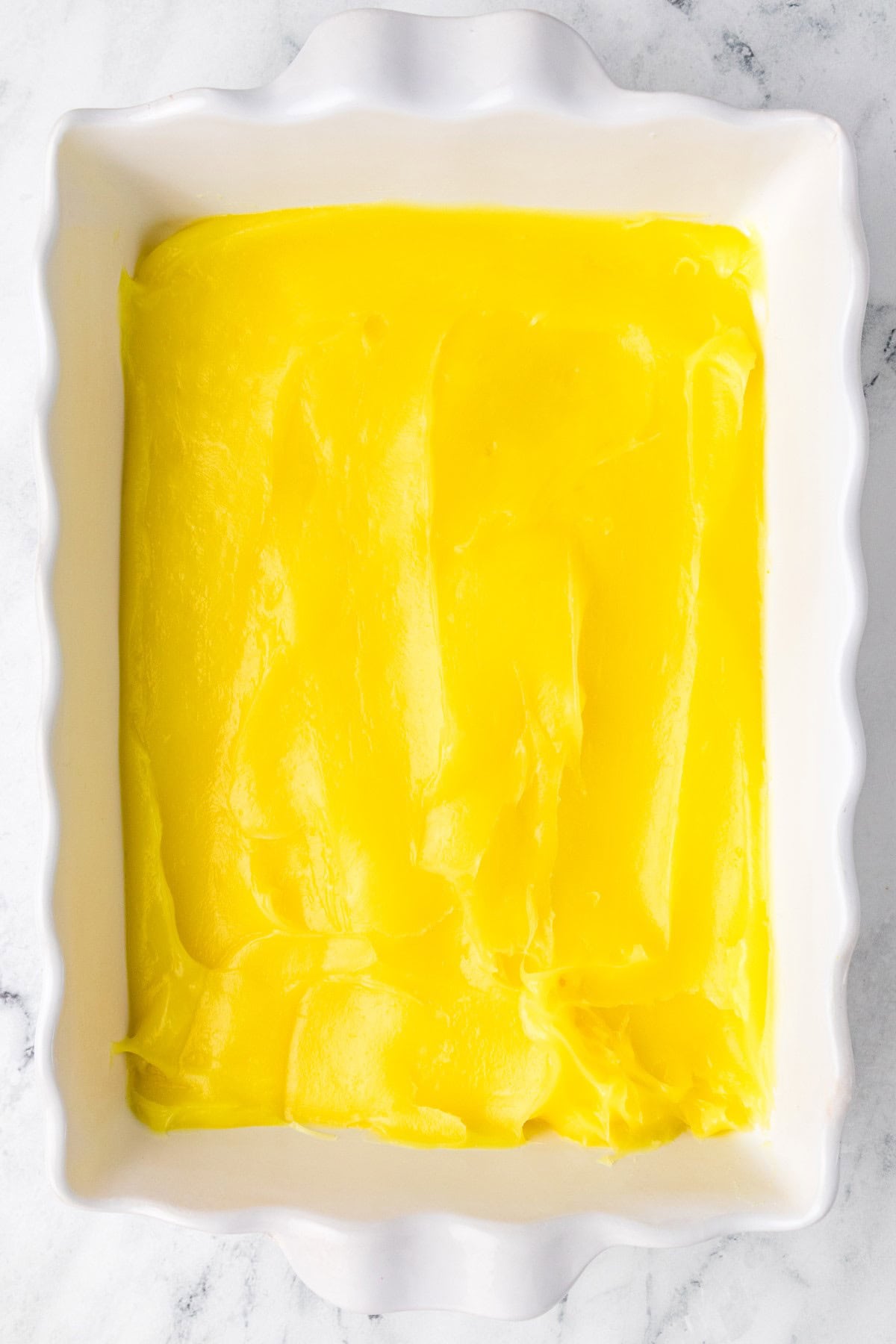 Need a quick and easy recipe? This Lemon Dump Cake is not only easy but delicious. It transports well, making a great potluck offering, and is summery and bright. Lemon lovers will be thrilled. Lemon filling layer.