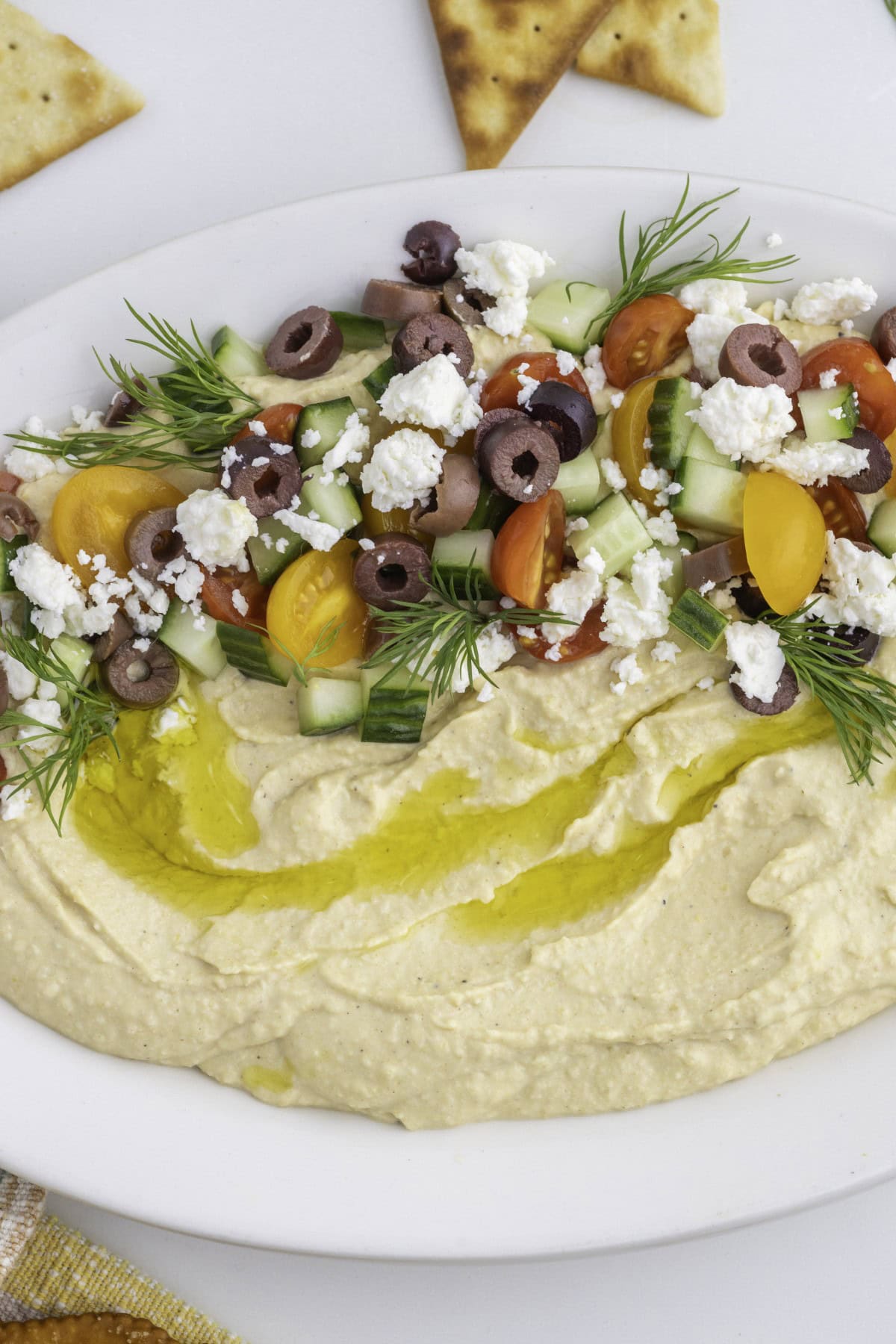 Want to up your appetizer to a healthy level without compromising flavor? Then try this amazing Loaded Hummus!! Everyone will dive into this delicious dish and you can watch it disappear. Close-up of loaded hummus, plate horizontal.