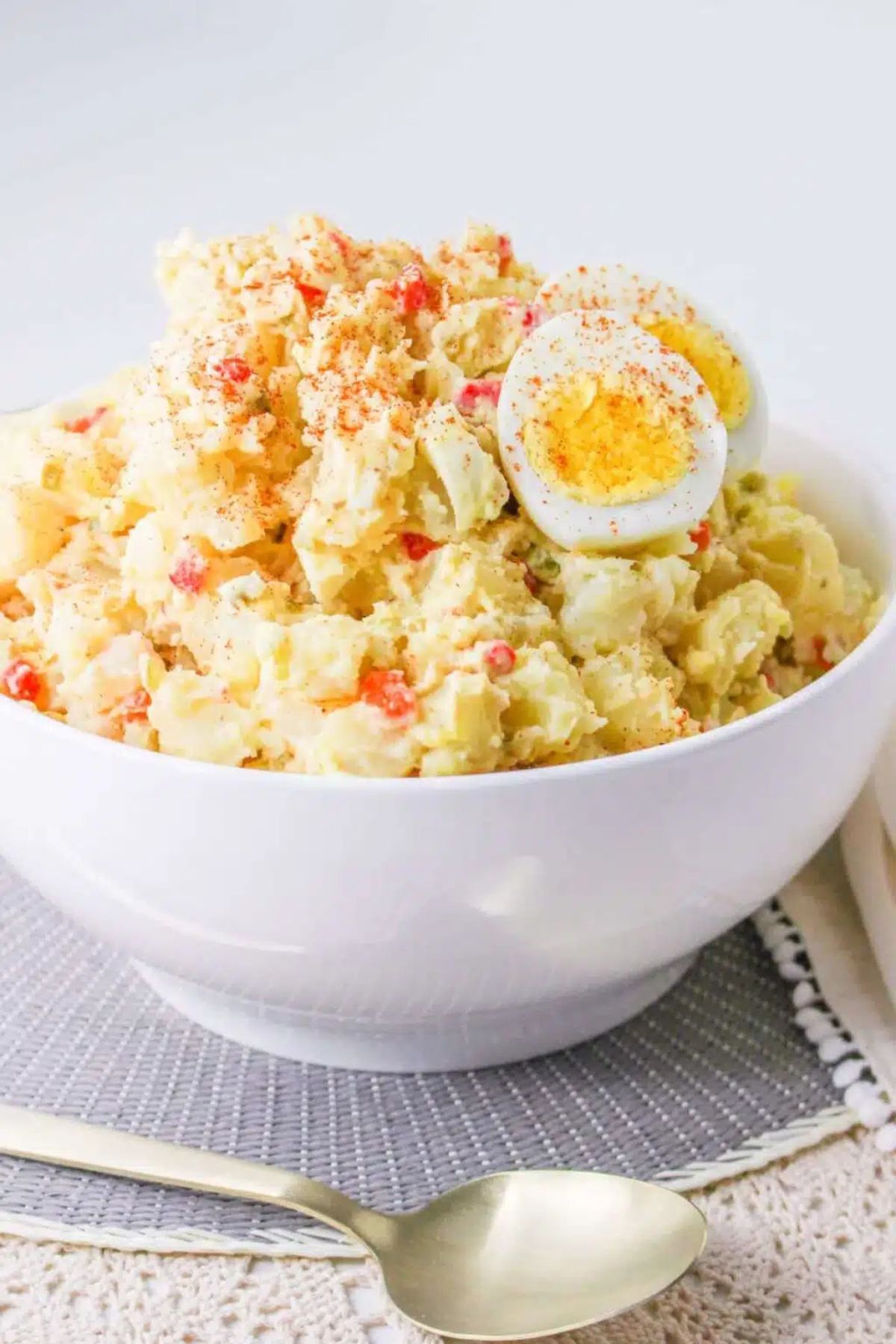 Get outside and enjoy the day with these 50 Picnic Basket Essentials. There is something for everyone to pack the perfect picnic and enjoy family time and the great outdoors. Bowl full of pimento potato salad with a hard boiled egg.