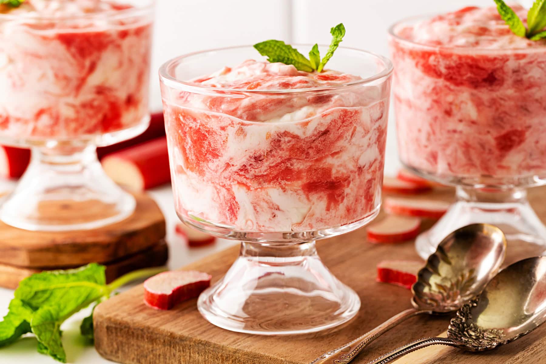 A delightful Rhubarb Fool is easy to make yet offers an elegant dessert. It is perfect after a BBQ in the spring and summer, as it is light as a cloud. Horizontal of rhubarb fool in glasses.