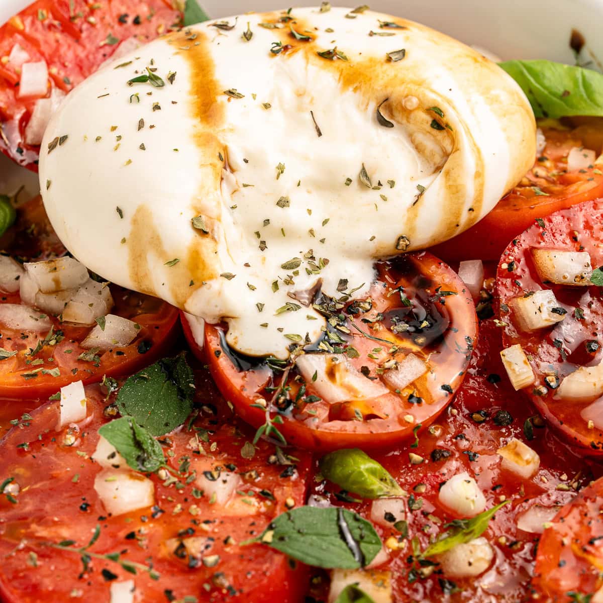 A Tomato Burrata Salad like this can be a show-stopper for any get-together. Use fresh heirloom tomatoes if available. They are the best with the creamy burrata. Burrata oozing onto tomatoes.
