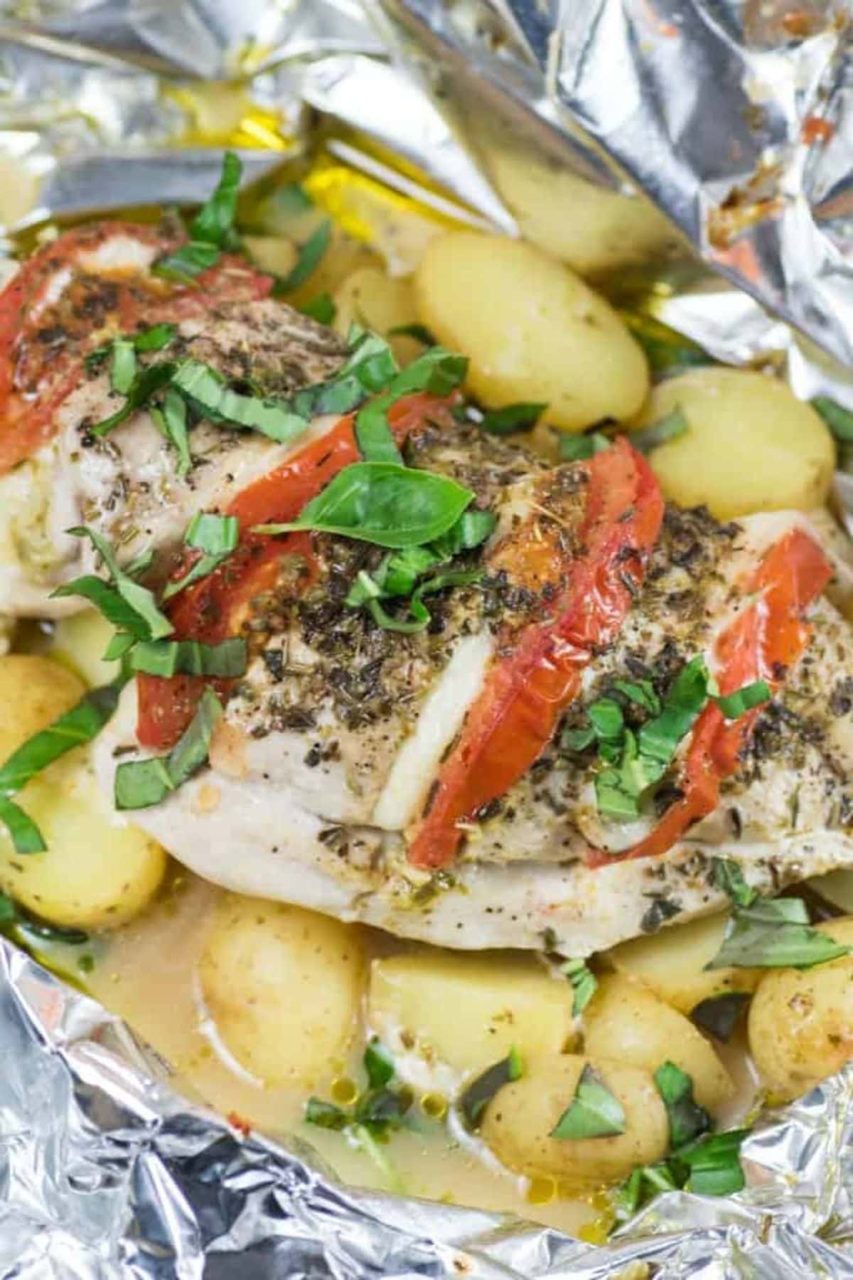 Are you enjoying the great outdoors this summer and wondering what to eat? Try some of these 20 Awesome Campfire Recipes!! Caprese chicken on top of potatoes in foil.