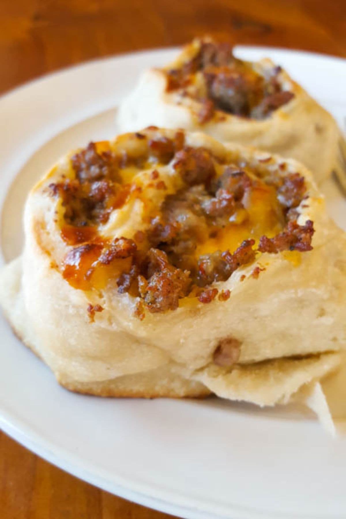 Are you enjoying the great outdoors this summer and wondering what to eat? Try some of these 20 Awesome Campfire Recipes!! Sausage breakfast pinwheel on a plate.