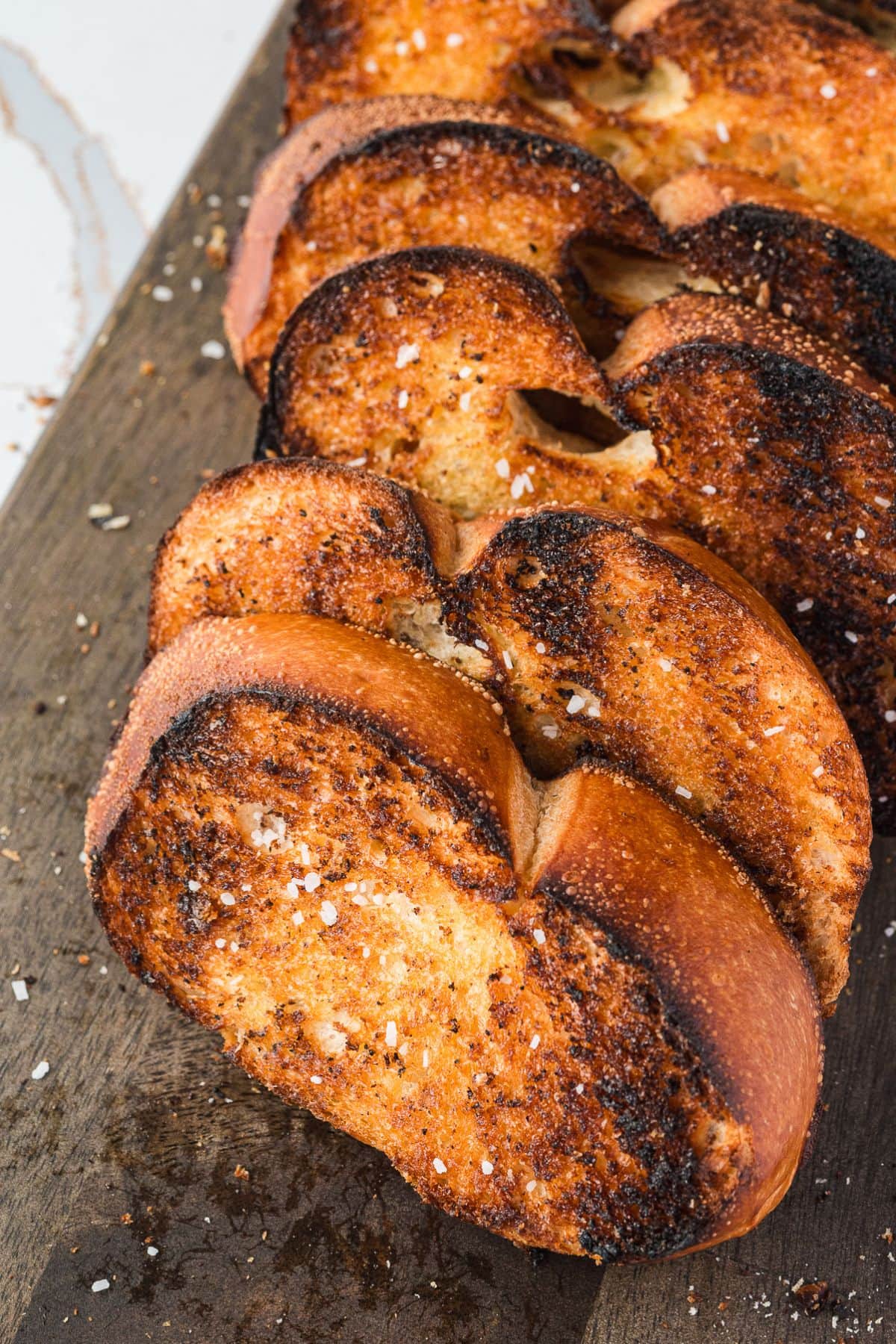 Are you enjoying the great outdoors this summer and wondering what to eat? Try some of these 20 Awesome Campfire Recipes!! Grilled garlic bread on a cutting board.