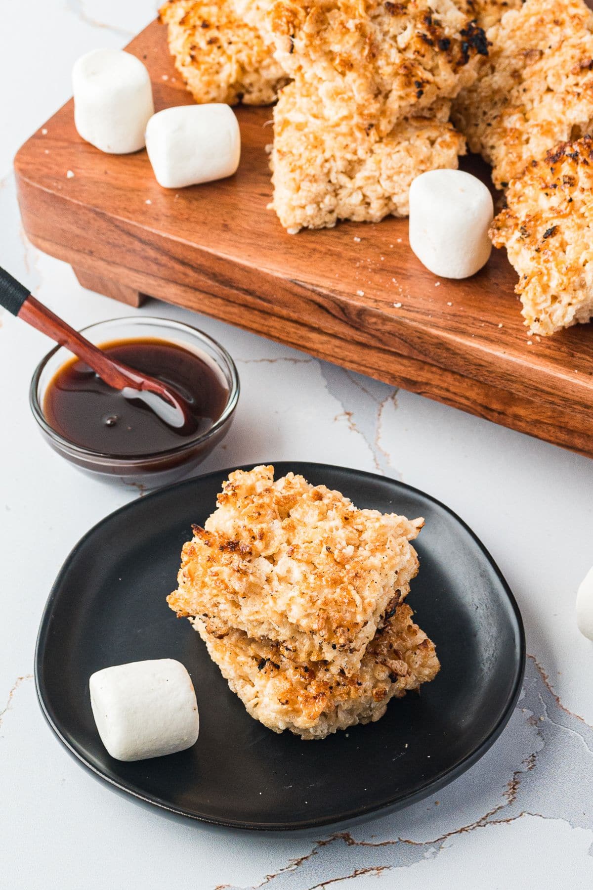 Are you enjoying the great outdoors this summer and wondering what to eat? Try some of these 20 Awesome Campfire Recipes!! Rice krispie treats on a small plate.