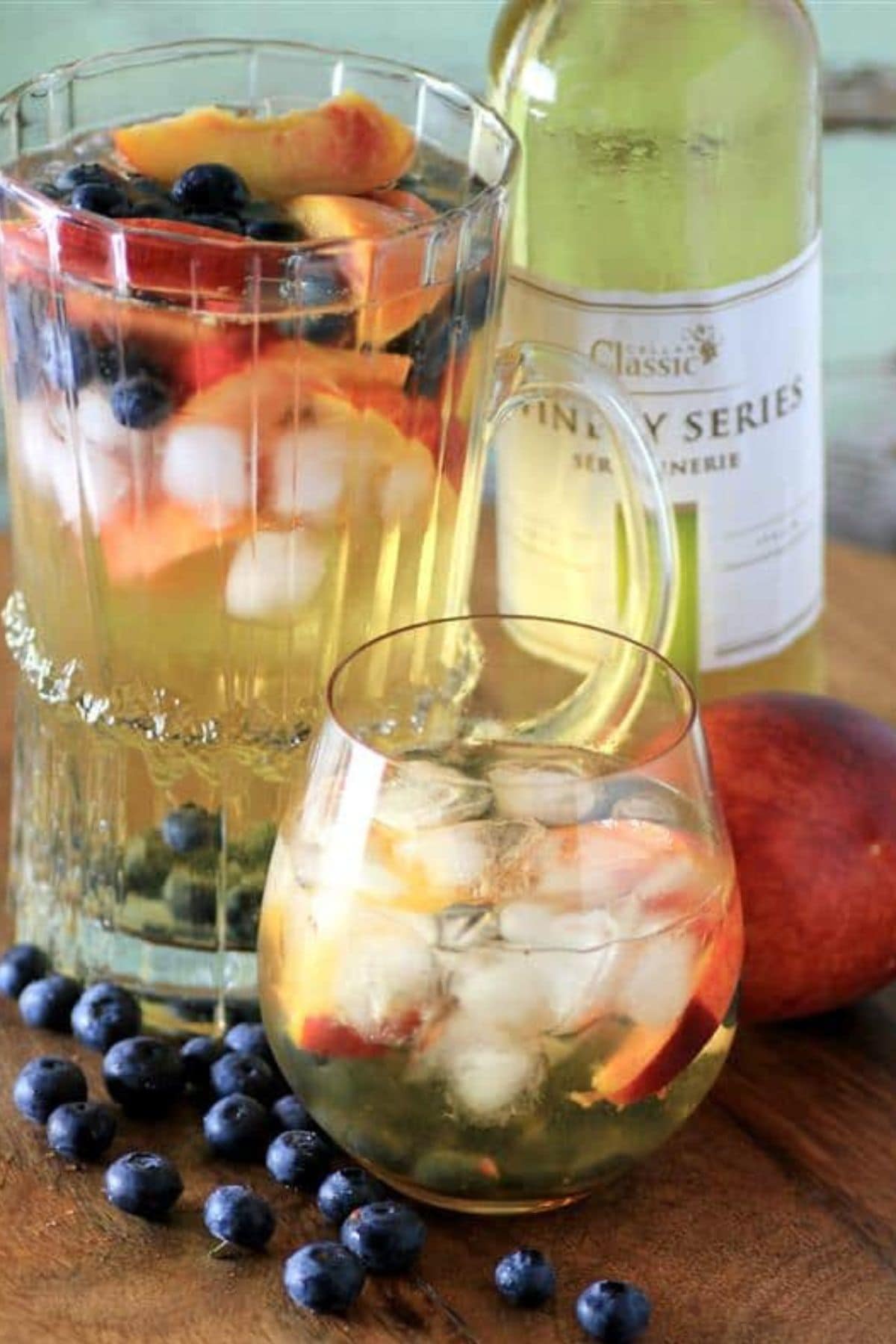 Get outside and enjoy the day with these 50 Picnic Basket Essentials. There is something for everyone to pack the perfect picnic and enjoy family time and the great outdoors. Glass full of peach blueberry sangria.