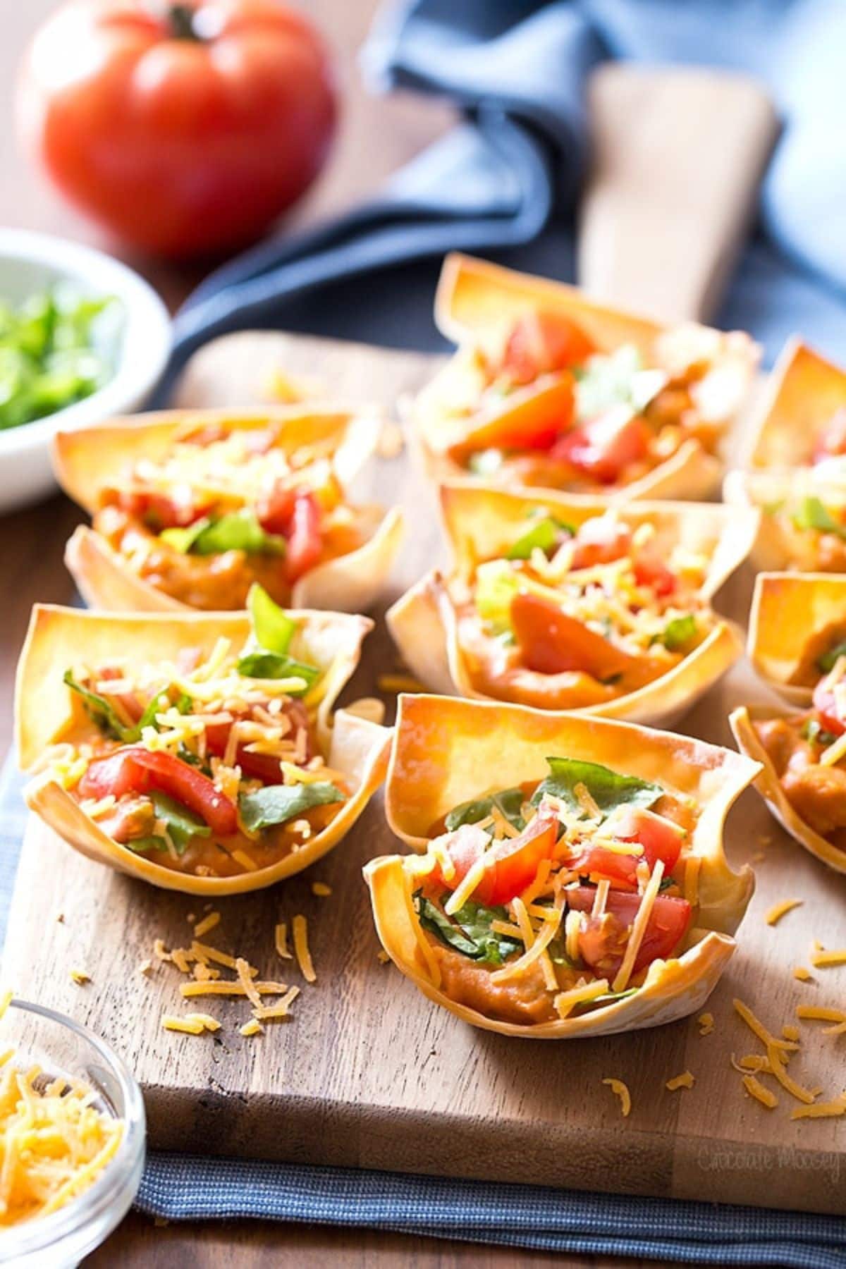 Taco cups on wooden cutting board.