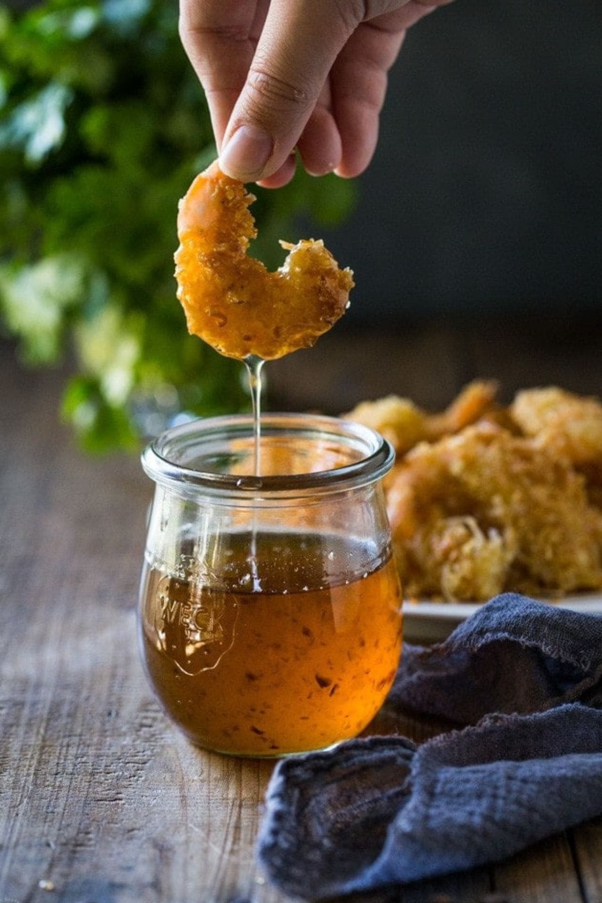 Shrimp being dipped in sauce.