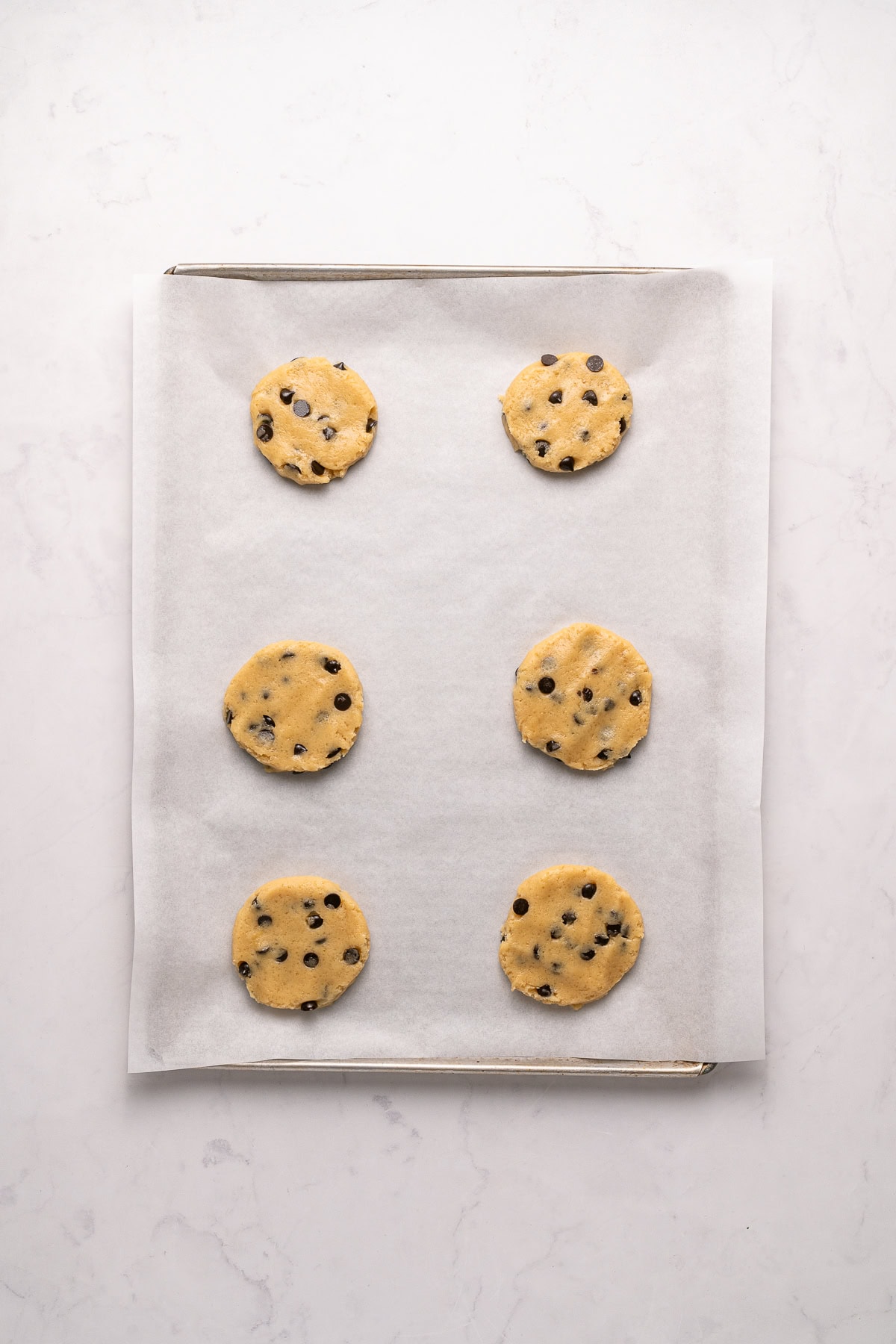 Make summer even more fun with these Cookie Ice Cream Sandwiches. These are a great make-ahead treat that is ready and waiting for you in the freezer for any time of the day. Flattening the cookies.