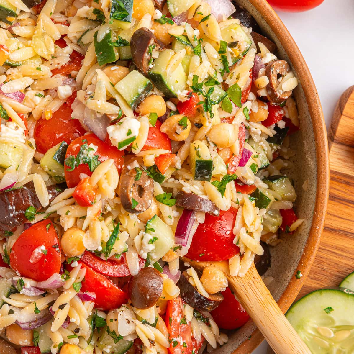 Another winner of a summer salad is this Greek Orzo Pasta Salad. It is easily portable, making it great for a picnic, BBQ or any gathering. It is hearty and healthy and full of flavors! Overhead close-up of orzo salad.