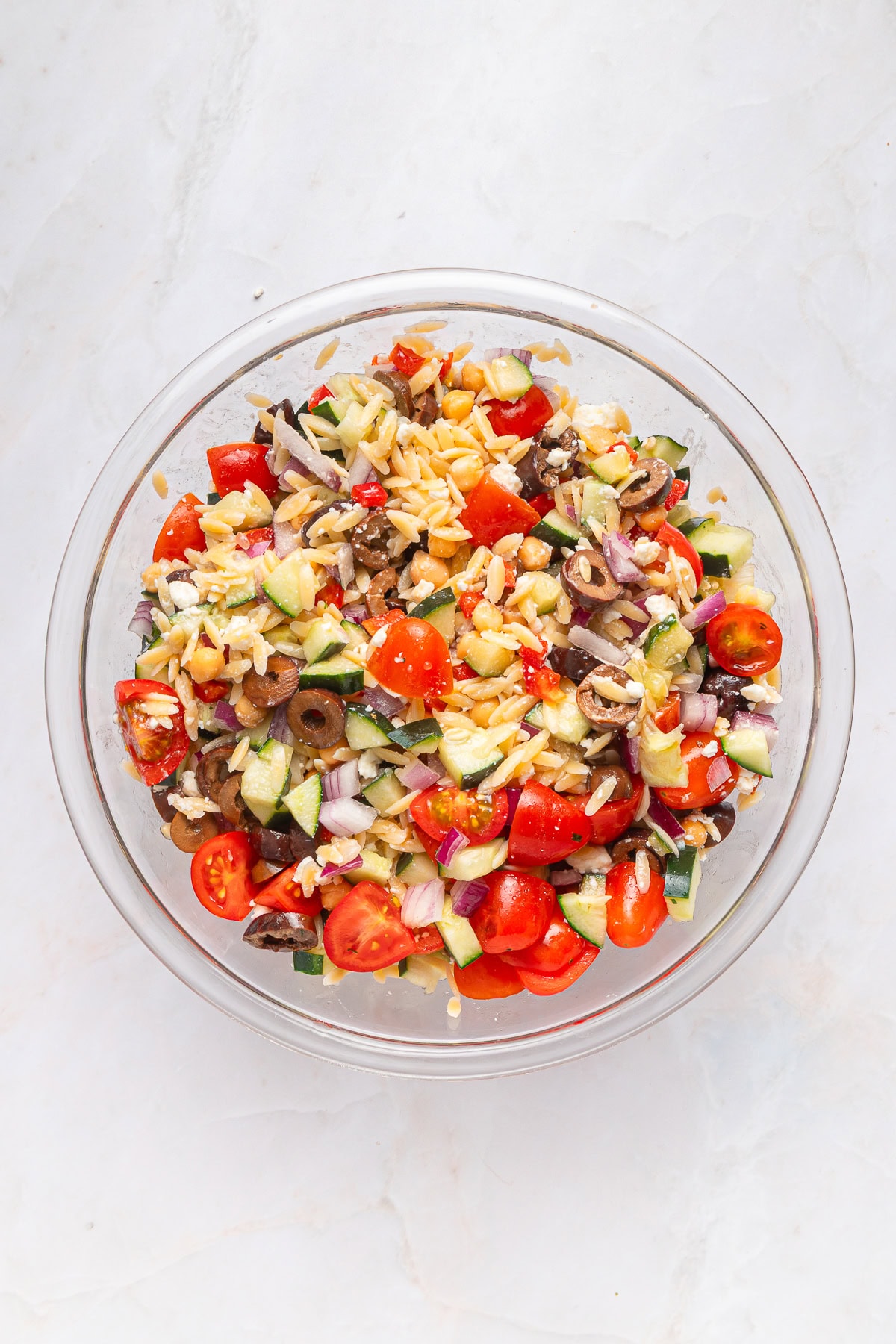 Another winner of a summer salad is this Greek Orzo Pasta Salad. It is easily portable, making it great for a picnic, BBQ or any gathering. It is hearty and healthy and full of flavors! Salad ingredients mixed.