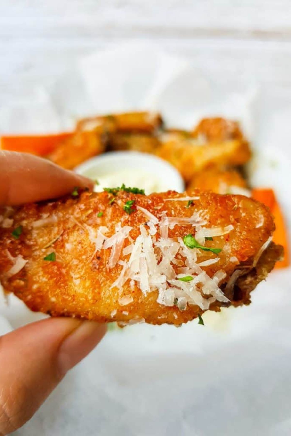 Wing held in a woman's hand.