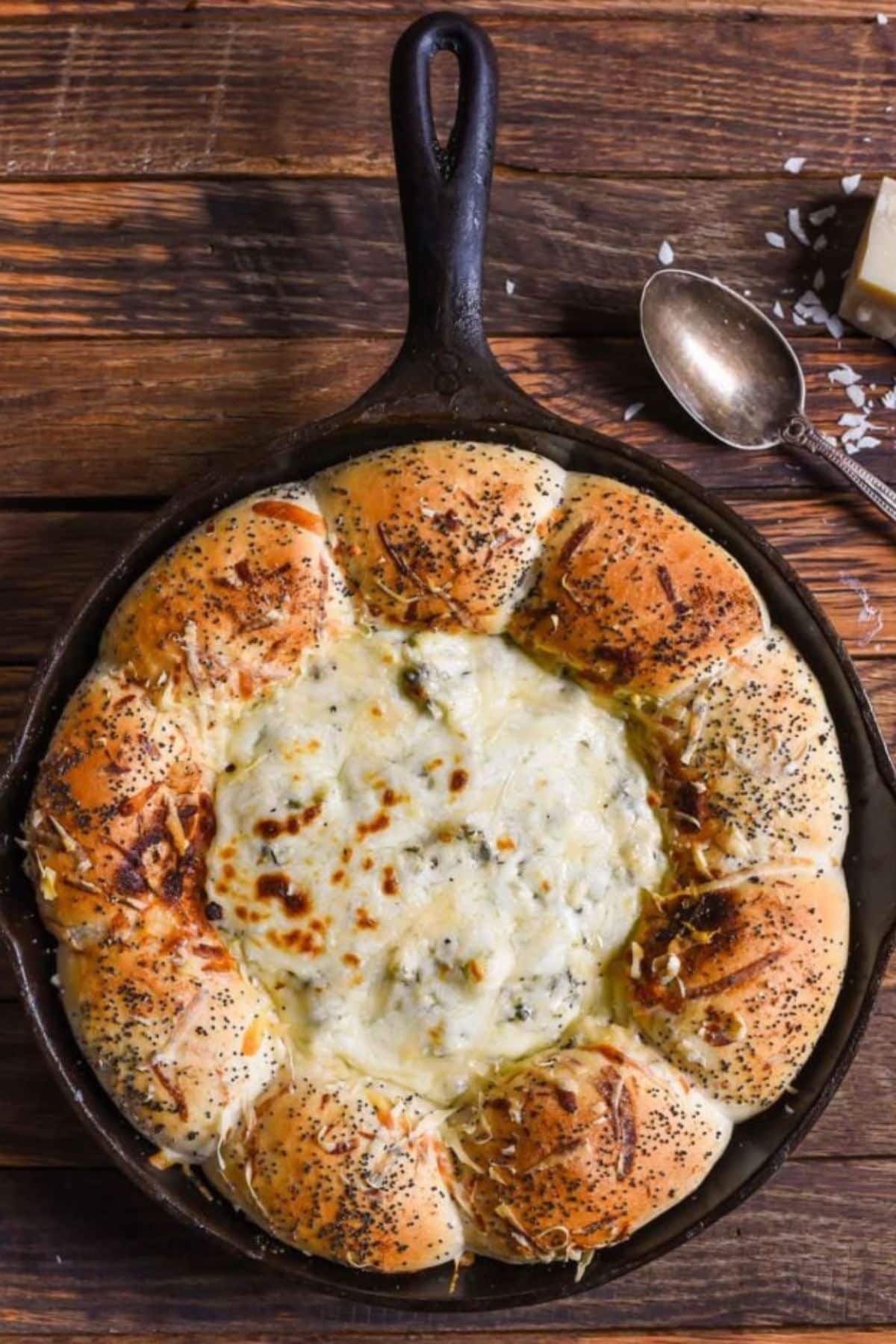 Cast iron skillet full of bread and dip.