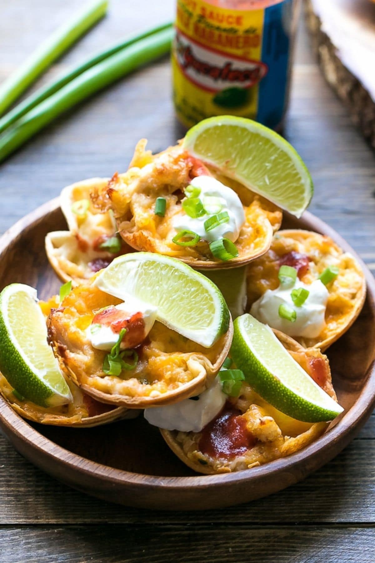 Plate of taco bites with lime wedges.