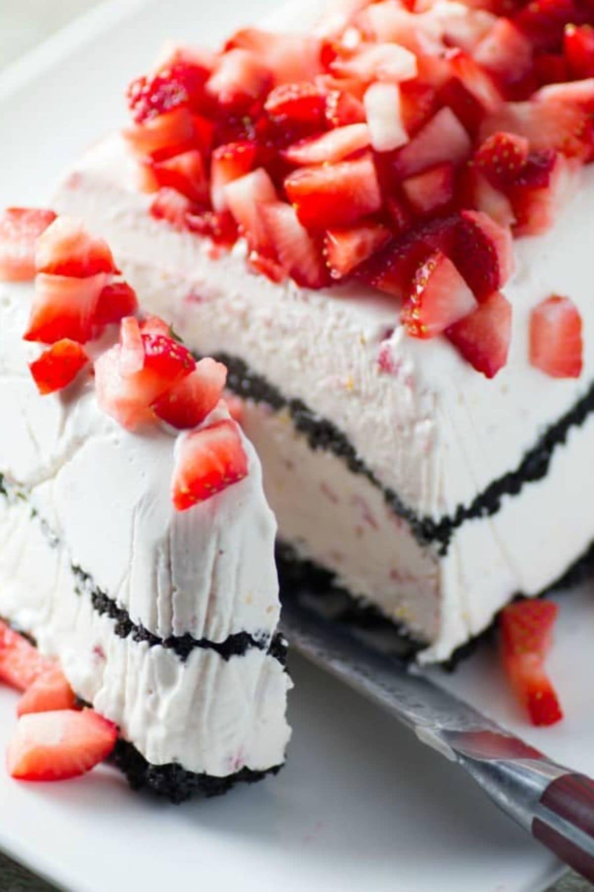 These 12 Canada Day Recipes are sure to please everyone at all your celebrations. Everyone will be diving in to enjoy all of these festive recipes. Slice of strawberry dessert being cut.