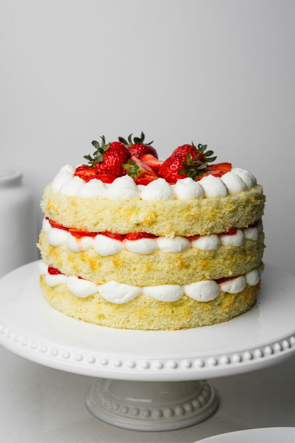 These 12 Canada Day Recipes are sure to please everyone at all your celebrations. Everyone will be diving in to enjoy all of these festive recipes. Strawberry shortcake on cake plate.