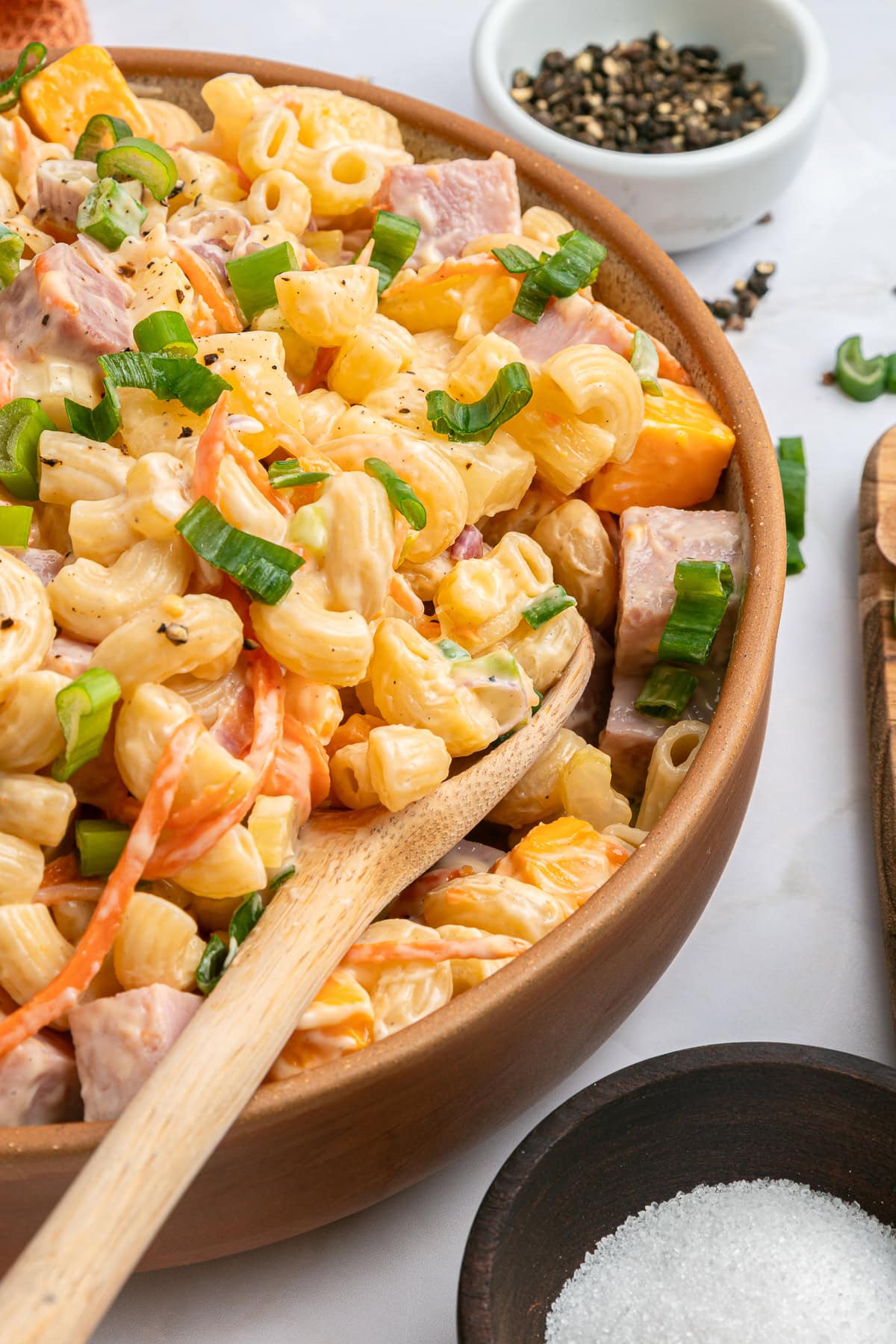 This Hawaiian Macaroni Salad is easy to pull together for a BBQ, gathering, picnic or even a lunchbox. It is inspired by a mouthwatering Hawaiian pizza. Hawaiian salad garnished with green onions.