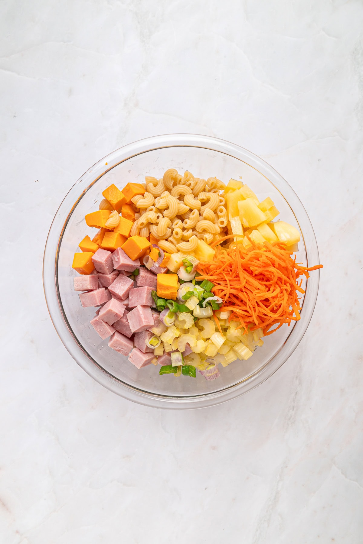 This Hawaiian Macaroni Salad is easy to pull together for a BBQ, gathering, picnic or even a lunchbox. It is inspired by a mouthwatering Hawaiian pizza. Preparing ingredients for the salad.