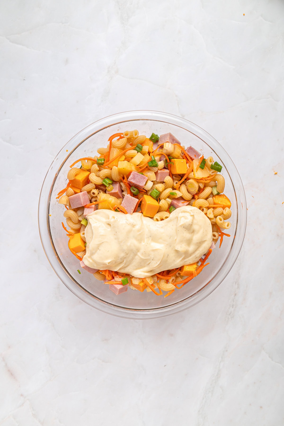 This Hawaiian Macaroni Salad is easy to pull together for a BBQ, gathering, picnic or even a lunchbox. It is inspired by a mouthwatering Hawaiian pizza. Mixing ingredients with creamy dressing.