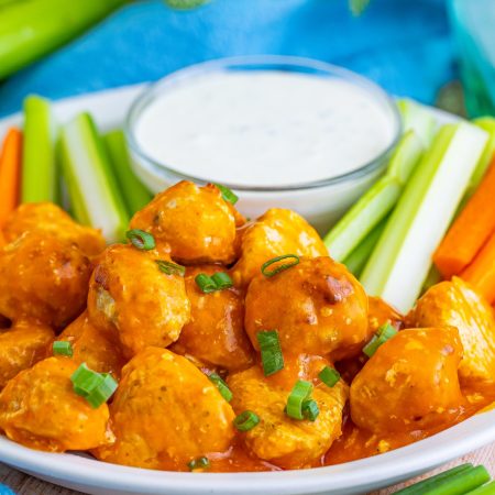 Buffalo Chicken Meatballs on a plate with veggies and dip.