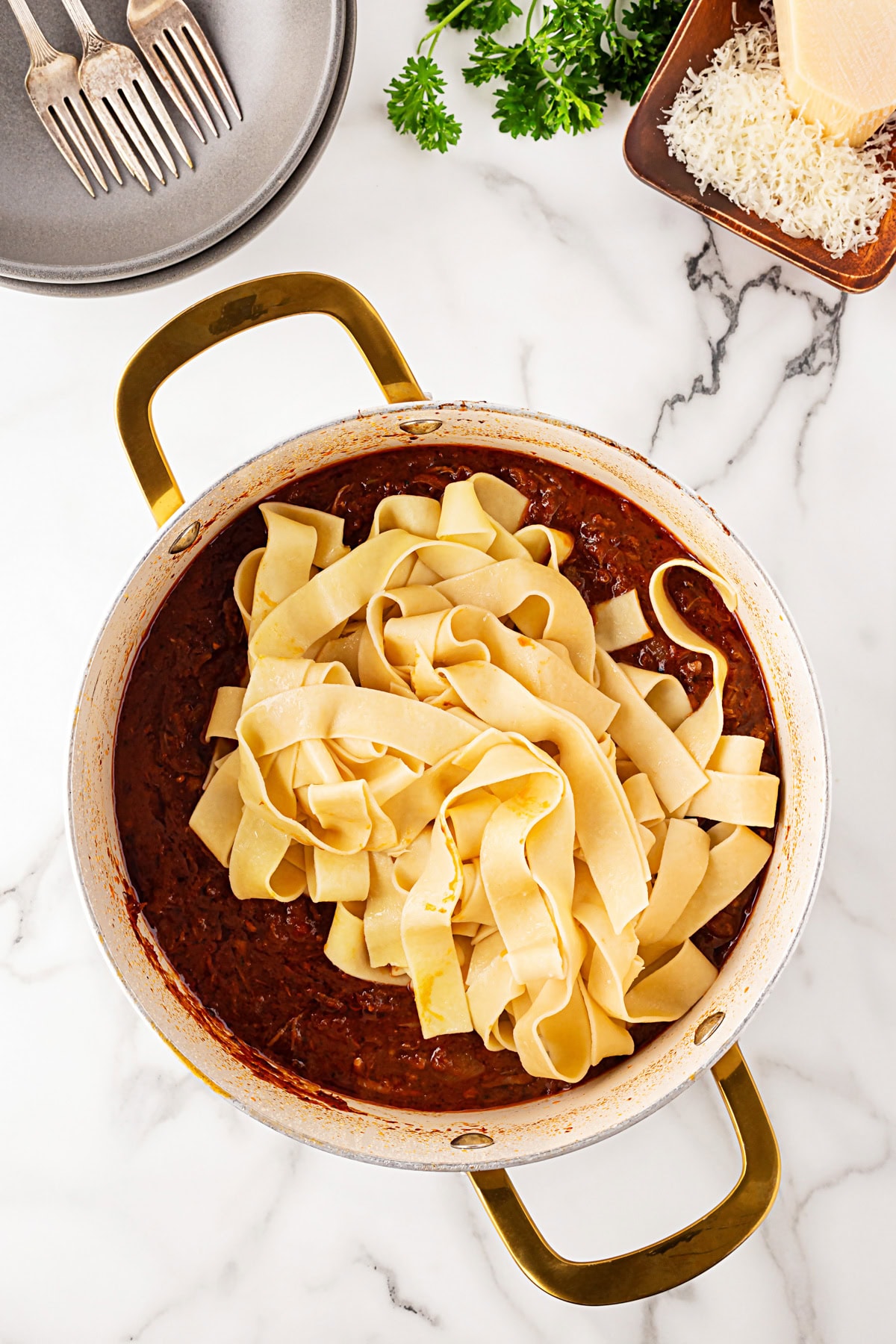 Adding pasta to the sauce. 