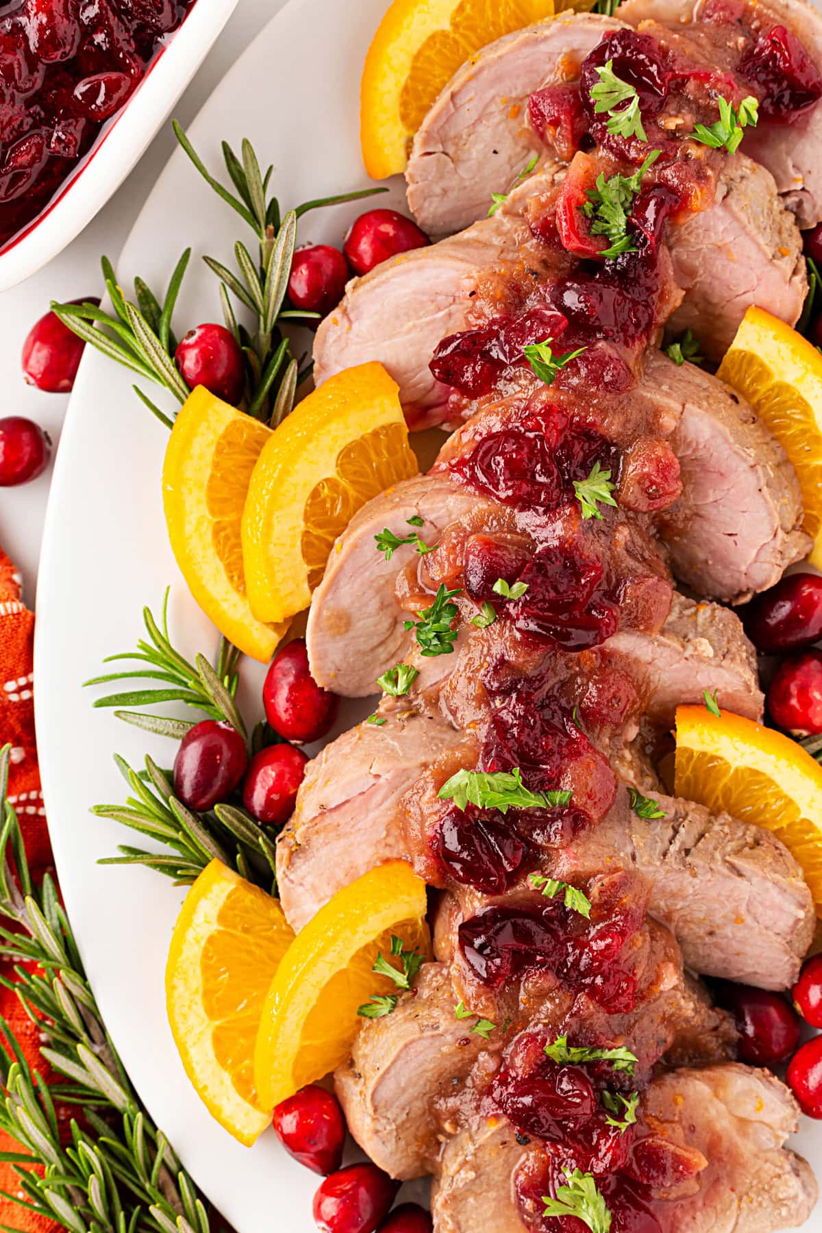 Slow Cooker Pork Tenderloin sliced with orange, rosemary and cranberries. 