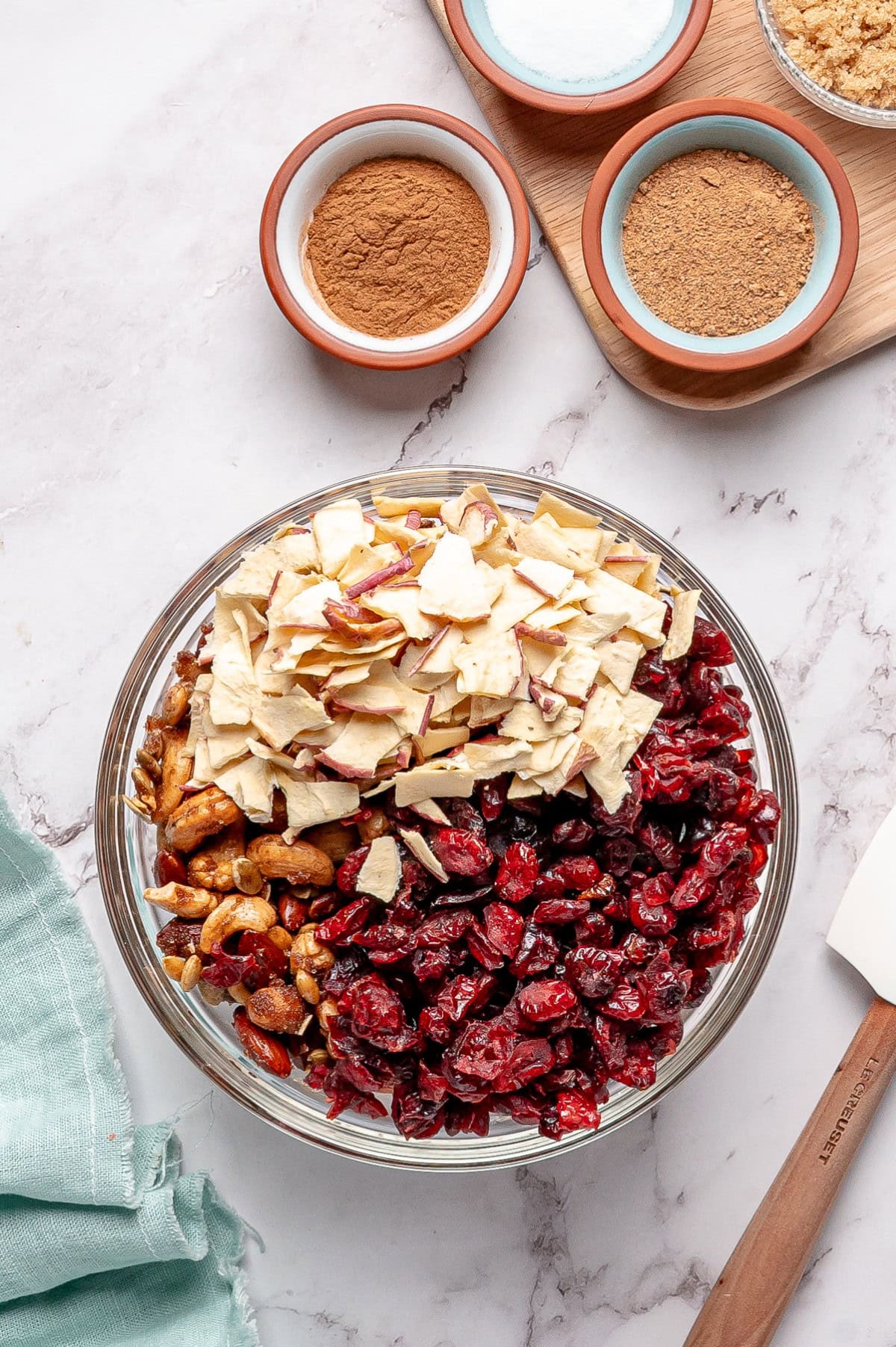 Apples and cranberries added in a bowl. 