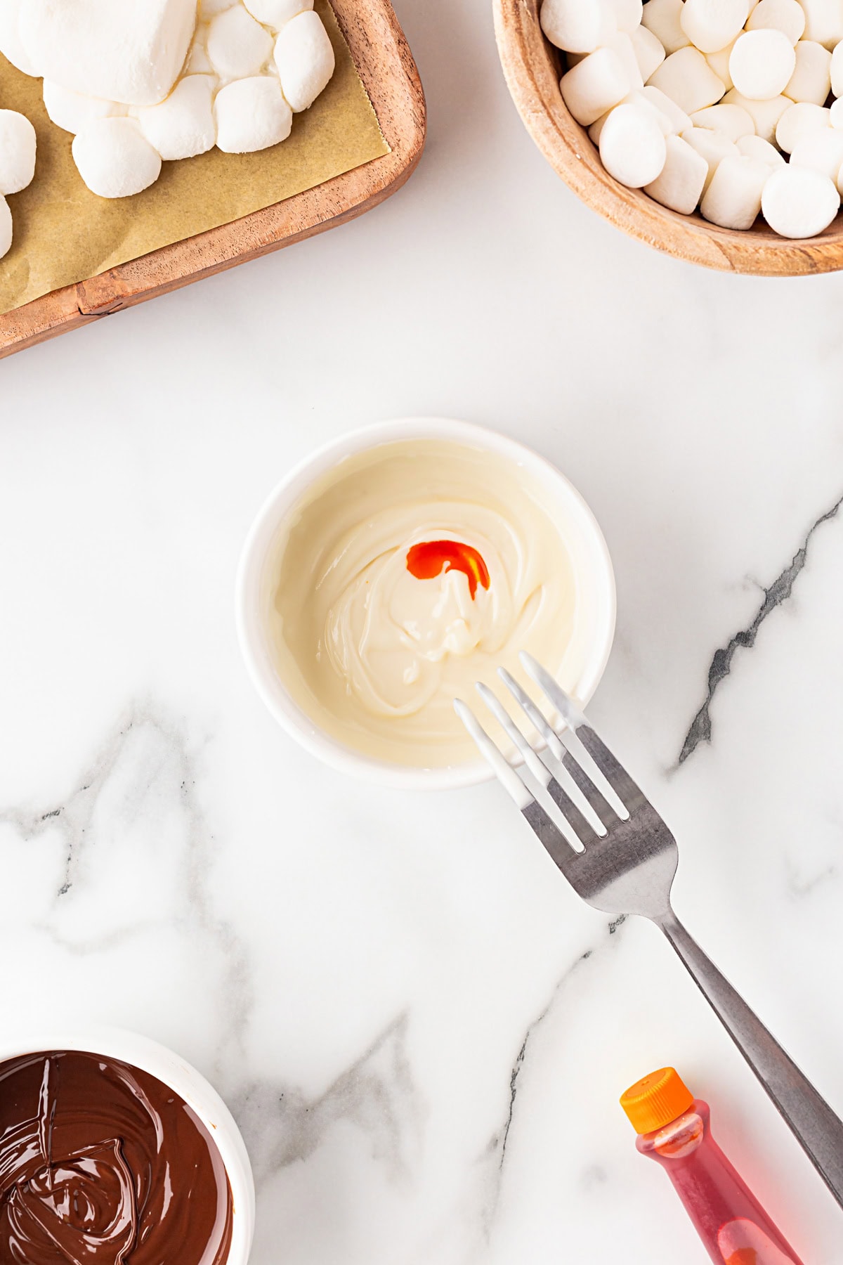 Adding food coloring to white chocolate. 