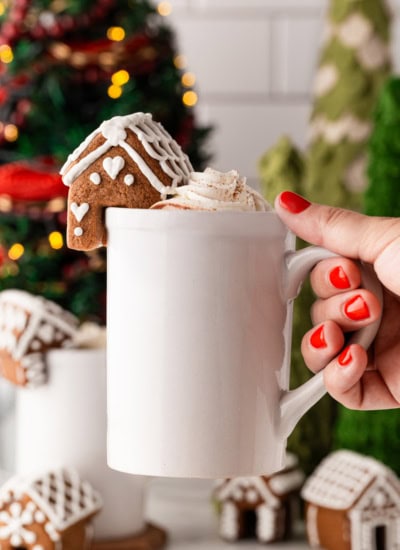 Holding a mug with a house on the side.