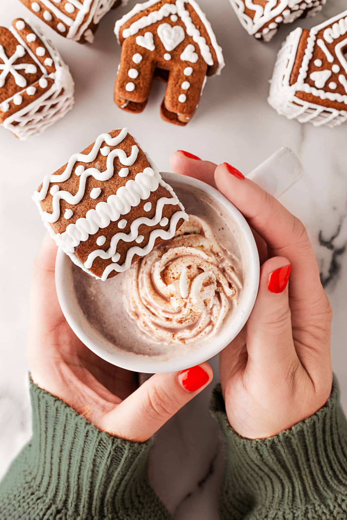 Holding a mug with a house on the side. 