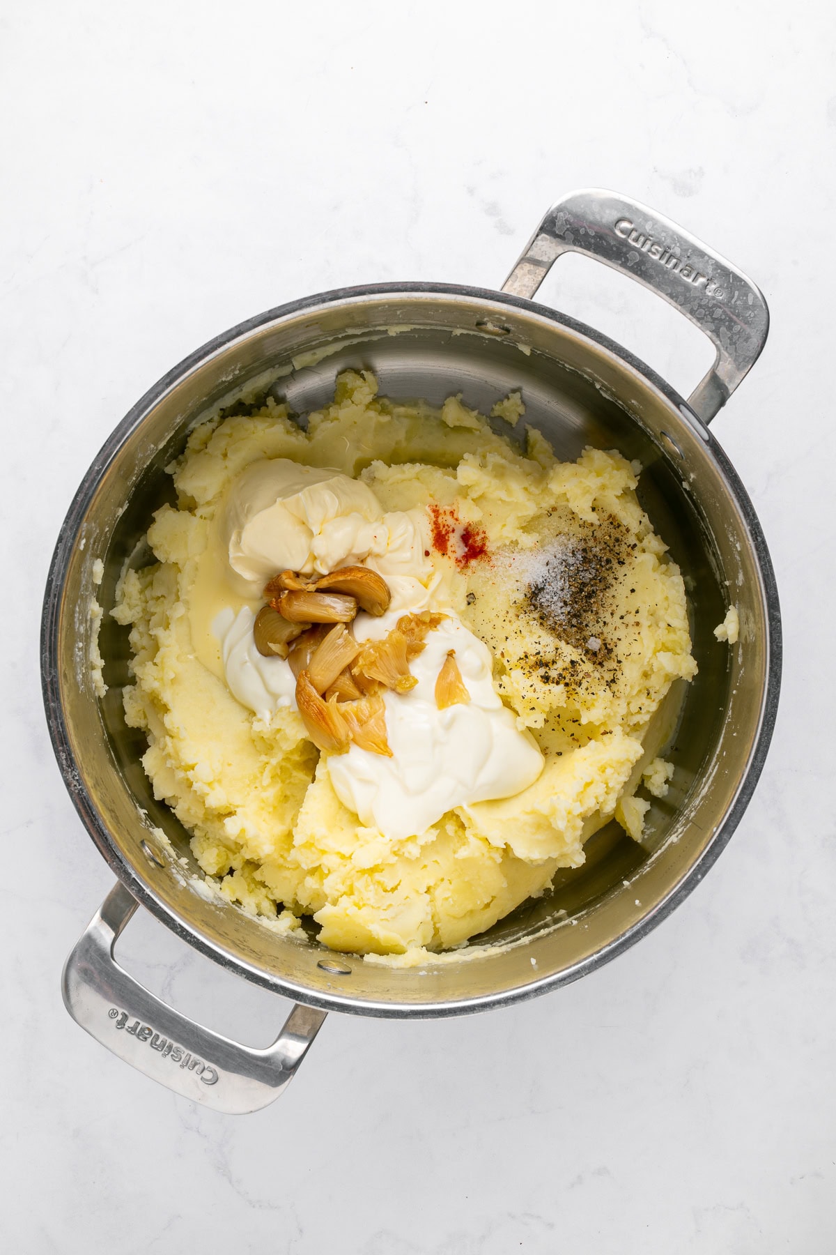 Incorporating the remaining ingredients into mashed potatoes.