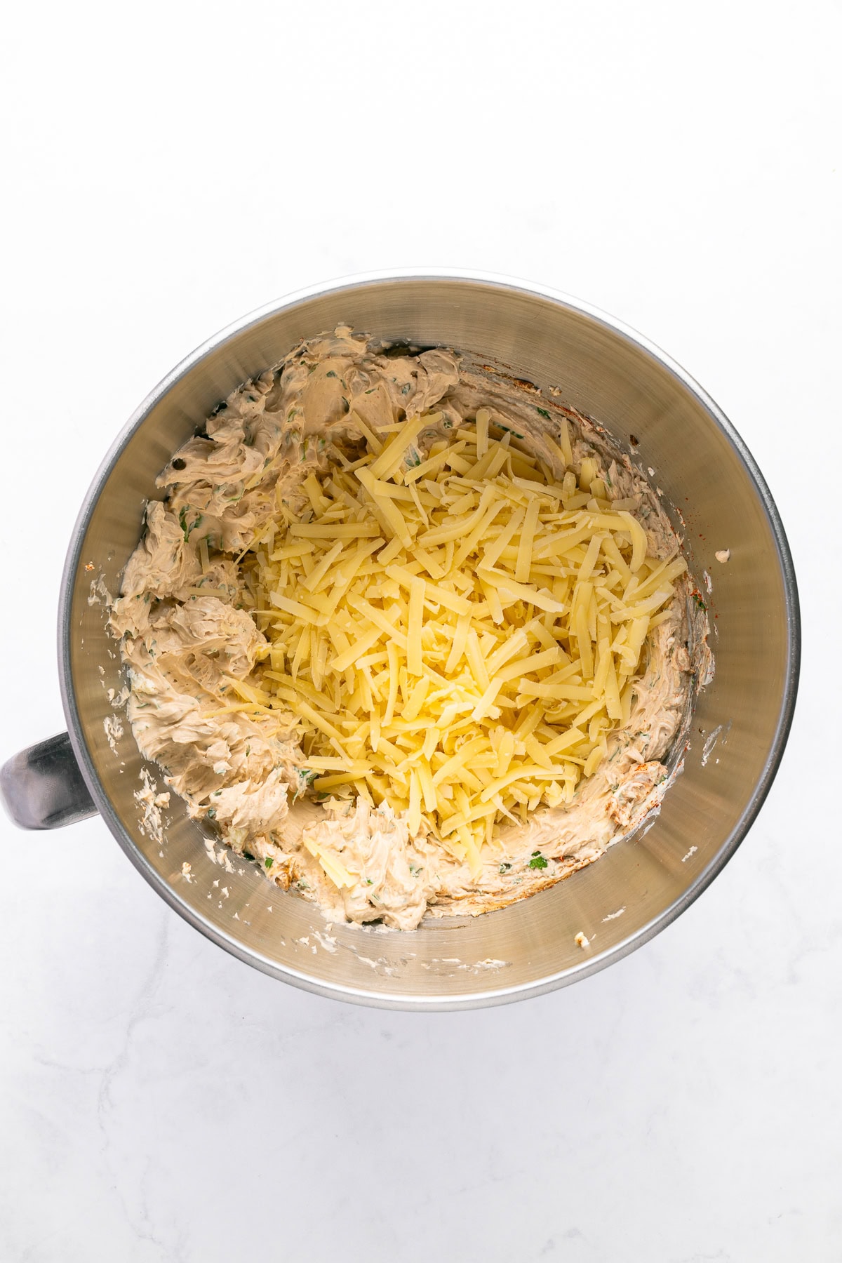 Adding shredded cheese. 