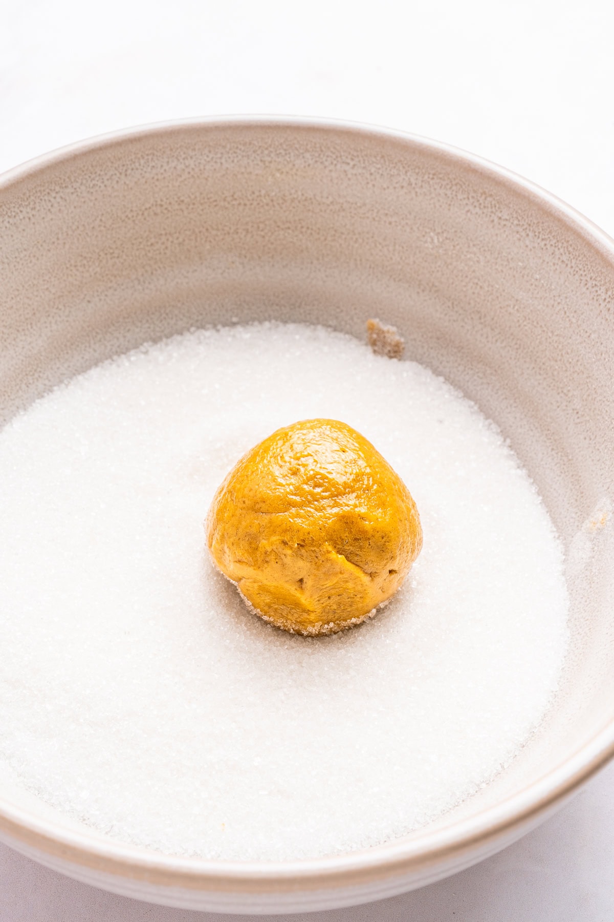 Rolling cookie balls in sugar.
